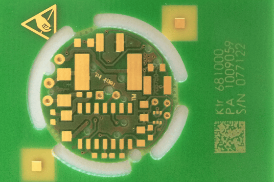 Drukarka do tabliczek znamionowych stosowana do trwałego znakowania okrągłej płytki elektronicznej PCB.