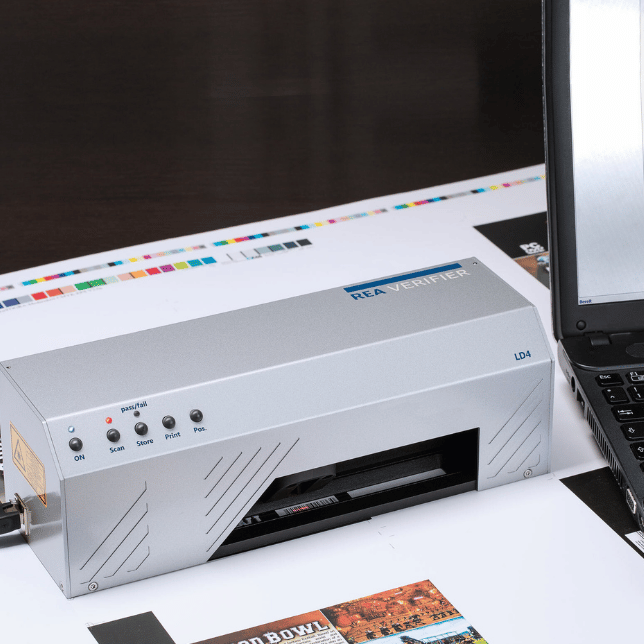 Stacjonarny system REA Verifier PC Scan LD4 wykonujący weryfikację kodów kreskowych w drukarni opakowań.