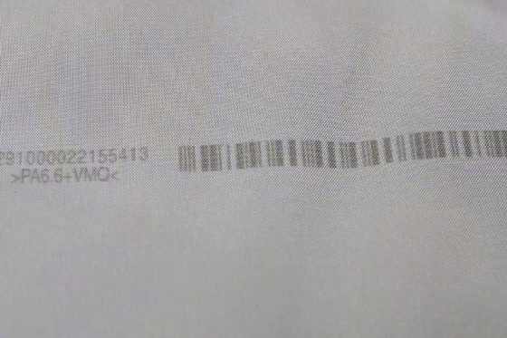 Kod kreskowy i dane identyfikacyjne nadrukowane bezpośrednio na materiale tekstylnym.