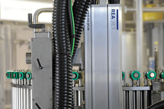 Przemysłowy system znakowania laserowego REA JET odporny na wilgoć i kondensację, pracujący na linii produkcyjnej.