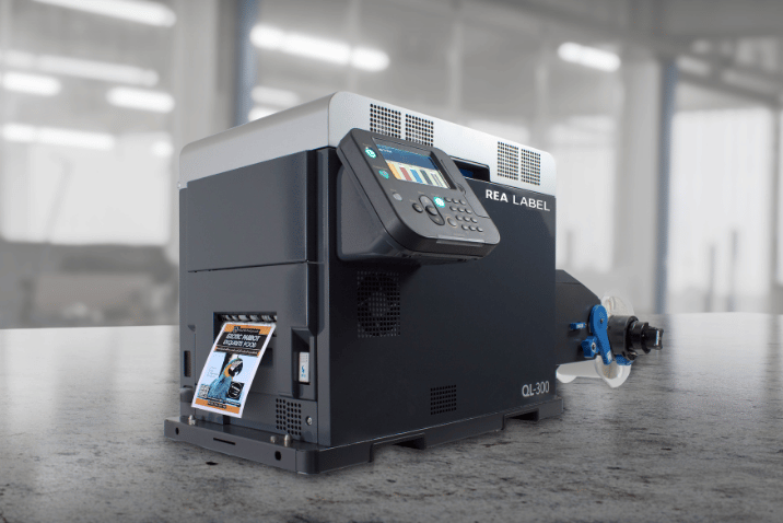 Przemysłowy system REA LABEL CL-300 do drukowania i automatycznego aplikowania etykiet na produkty i opakowania.