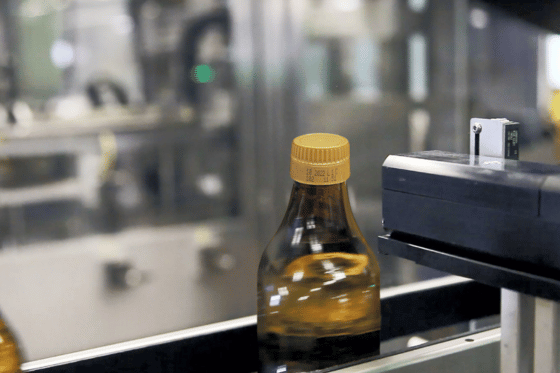 Drukarka CIJ znakująca szklaną butelkę na przemysłowej linii produkcyjnej