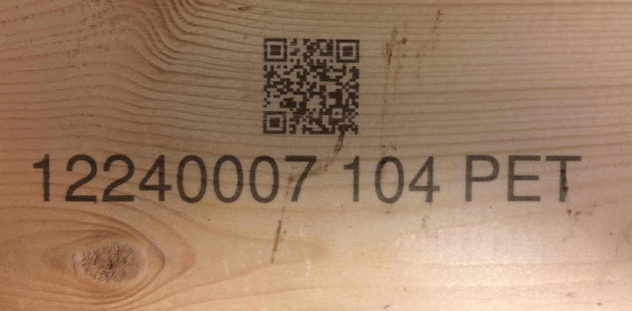 Kod QR i numer identyfikacyjny naniesione na deskę drewnianą