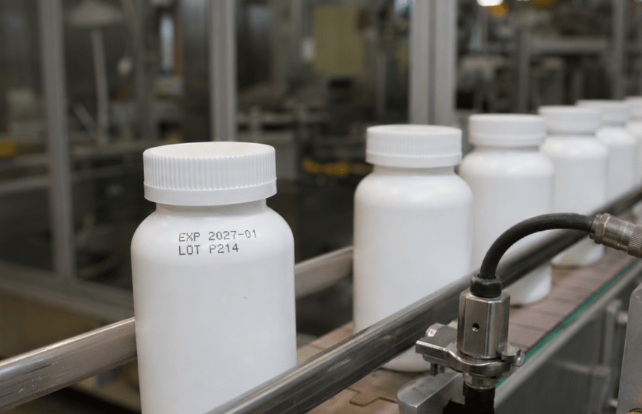 Białe plastikowe butelki na linii produkcyjnej z nadrukowaną datą ważności i numerem partii LOT