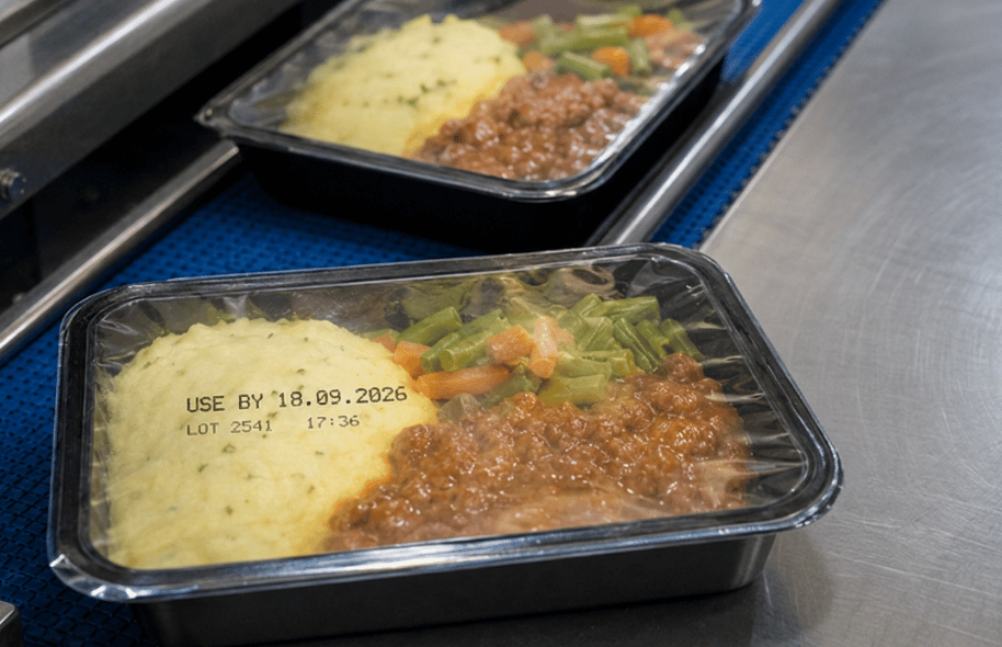 Tacka z gotowym daniem z nadrukowaną datą „use by”, numerem LOT i godziną produkcji