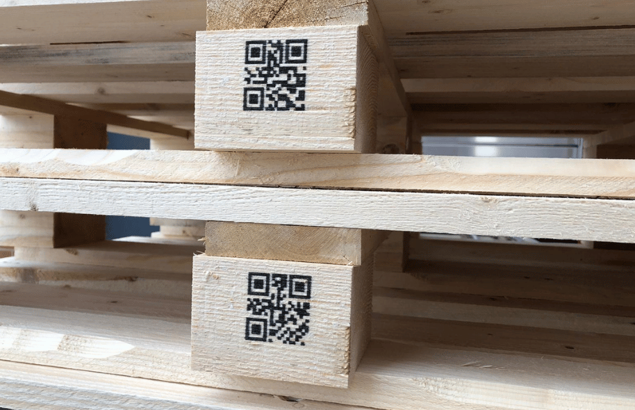 Kody QR nadrukowane na drewnianych elementach palety w procesie znakowania drewna