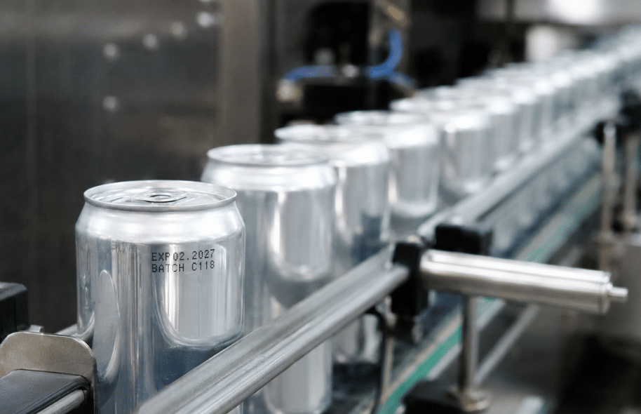 Aluminiowe puszki na linii rozlewniczej z nadrukowaną datą ważności i oznaczeniem partii