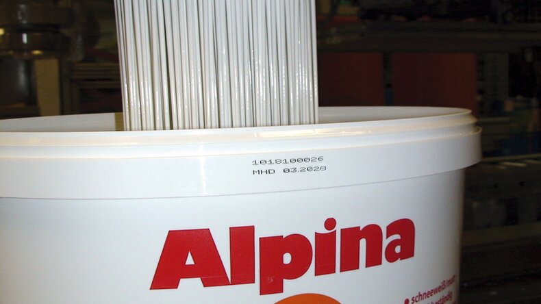 Wiadro z farbą Alpina z nadrukowanymi danymi produkcyjnymi nad etykietą produktu