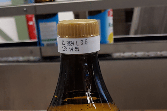 Data i dane produkcyjne nadrukowane na szyjce szklanej butelki