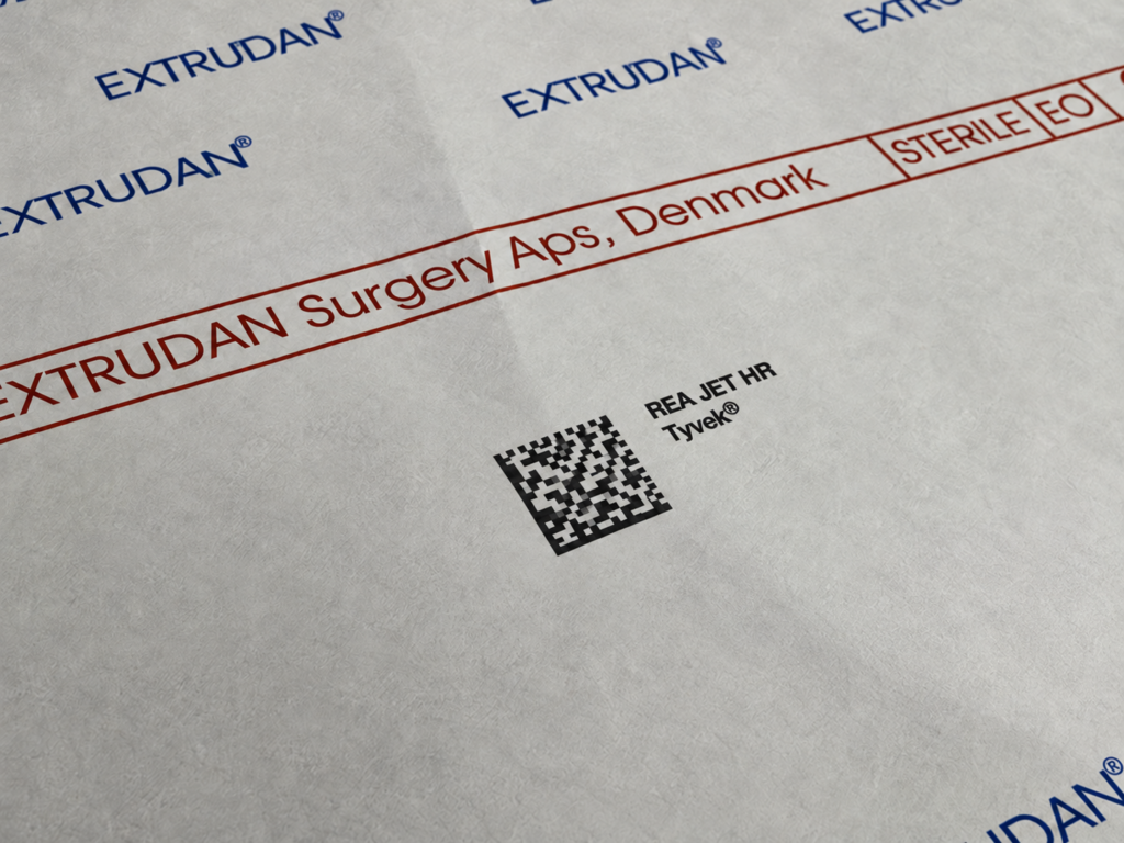 Kod DataMatrix i nadruk REA JET HR na materiale Tyvek z oznaczeniami EXTRUDAN oraz STERILE EO na opakowaniu medycznym.